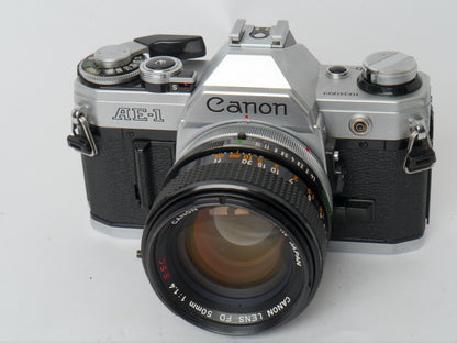 Canon AE-1 Gehäuse silber mit FD 1,4/50mm S.S.C. – mit Canon 299A Blitzgerät gut
