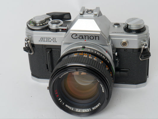 Canon AE-1 Gehäuse silber mit FD 1,4/50mm S.S.C. – mit Canon 299A Blitzgerät gut