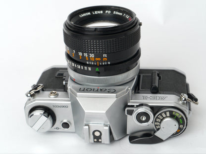 Canon AE-1 Gehäuse silber mit FD 1,4/50mm S.S.C. – mit Canon 299A Blitzgerät gut