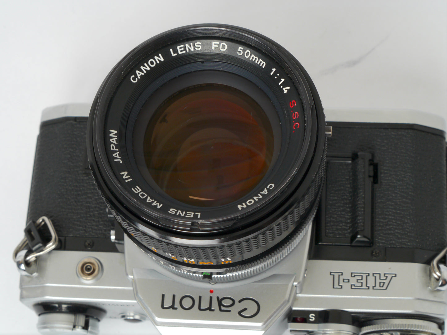 Canon AE-1 Gehäuse silber mit FD 1,4/50mm S.S.C. – mit Canon 299A Blitzgerät gut