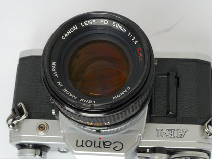 Canon AE-1 Gehäuse silber mit FD 1,4/50mm S.S.C. – mit Canon 299A Blitzgerät gut